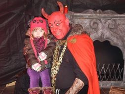 man in a devil costume and a little child