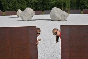 girl and boy play near big stones