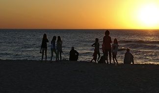 People admiring the sunset on the background of the Baltic Sea