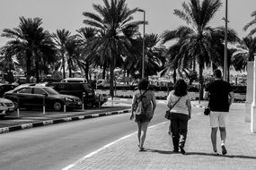 Black and white photo of tourists waking on the path in Dubai