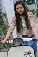 girl with long hair on a motor scooter