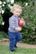 little boy with easter egg in his hands in a garden