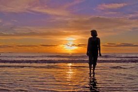 silhouette of a woman on the beach at sunset background