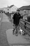 man walking with dog on street in village