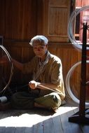 woman spins silk in Myanmar