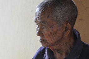 old man sitting near the wall
