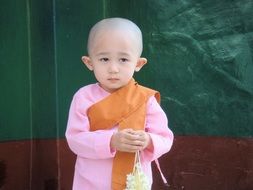 a child in a pink monk dress in Myanmar (formerly Burma)