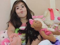 girl with sunken cheeks among toys