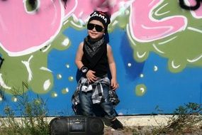 little boy in the style of hip-hop on the background of graffiti