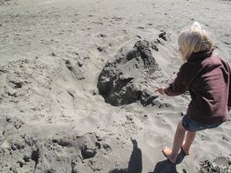 child and his shadow on a sandy beach