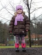 little girl in warm clothes in the field