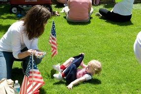 little girl with flag on green grass