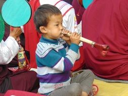 small boy playing with musical instrument
