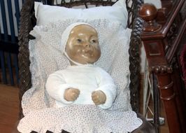 doll in a wooden crib close-up
