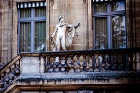 statue of a man on the facade of a building in Paris