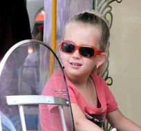 girl sunglasses funfair bicycle