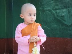 a diffident child in a pink monk dress in Myanmar (Burma)