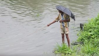 fishing man with umbrella