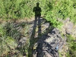 the elongated shadow of a man on the ground