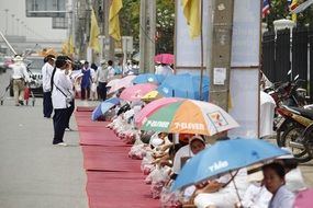 praying buddhists on the street, thailand