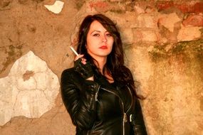 seductive girl in a leather jacket with a cigarette