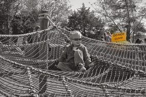 monochrome photo of funny child on the rope attraction