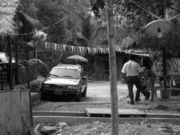 Black and white photo of a man near a car in Colombia