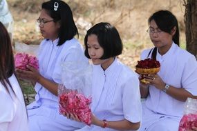 women holding petals for buddhist ceremony, thailand