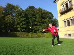 mature man playing sokieba on lawn