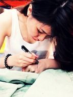 girl draws henna paint on her hand