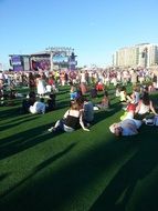 people is sitting on the lawn at a concert