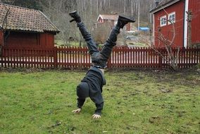 the child is standing on hands on the grass