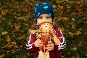 child with a scarecrow of doll in hands
