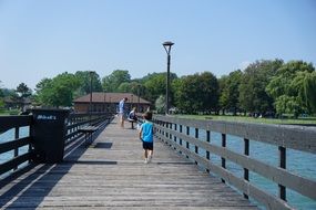 child walks on a wooden pier