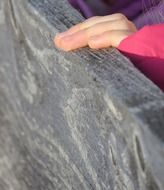 child's hand on a wooden plank