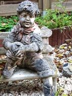 stone statue of a boy in a garden