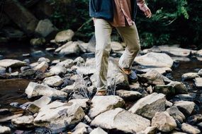 man crossing creek