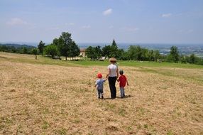 mother and sons walking in the field