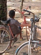 baby sits on a bike in cambodia