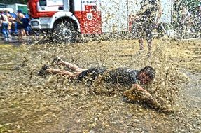 a man lies in a muddy puddle