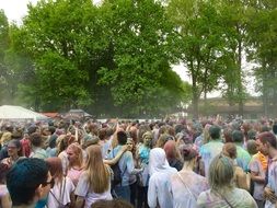 a crowd of people at a festival in the park