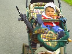 cute baby girl in a baby carriage with pacifier