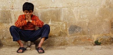 boy sitting against wall