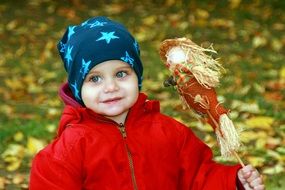 portrait of a child with a scarecrow's doll in the hands