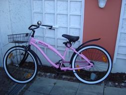 pink bicycle stands near the wall