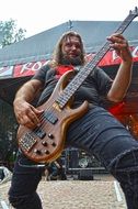 cool bearded man playing guitar on podium