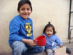 brother and sister are eating on the street in Peru