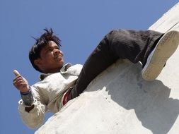 happy indian child on the wall on a sunny day