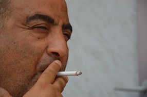 Adult man mediterranean smoking cigarette