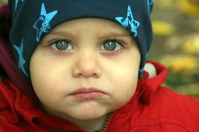 child with beautiful eyes satisfies hunger in the park